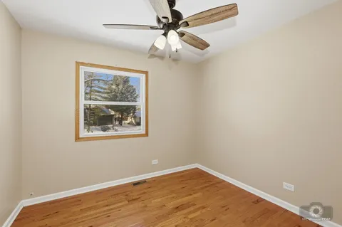 an empty room with a window and a fan