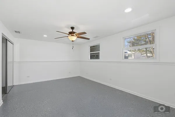 a view of a livingroom with wooden floor and a ceiling fan