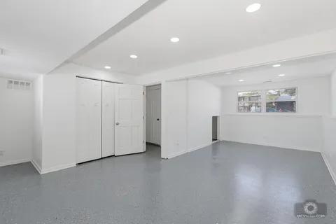 a view of an empty room with wooden floor and windows