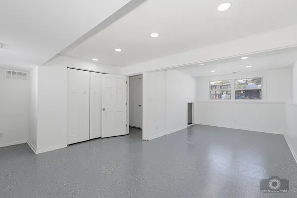 a view of an empty room with wooden floor and windows