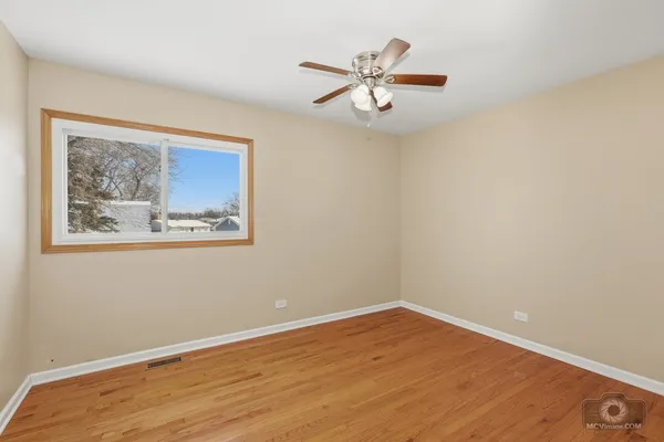 a view of empty room with wooden floor