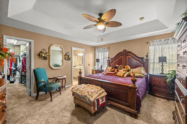 a bedroom with a bed a window and a mirror on a dresser