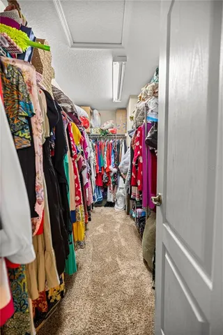 a view of walk in closet with clothes