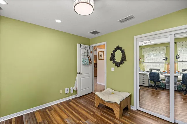 a view of a hallway with wooden floor and a living room