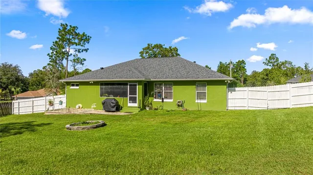 a view of a house with a yard and large tree