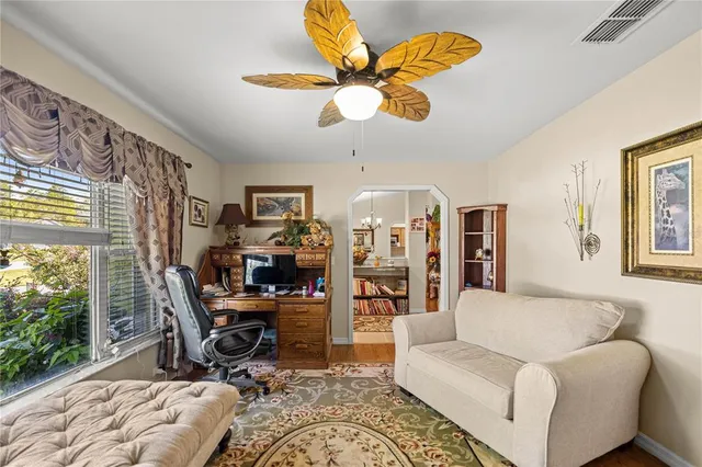 a living room with furniture a chandelier and a large window