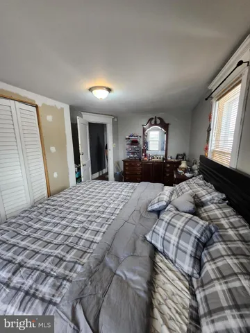 a bedroom with a bed and a large mirror