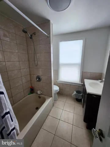 a bathroom with a tub a sink a mirror and a shower