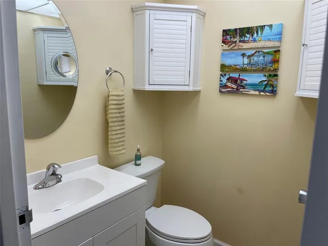a bathroom with a sink vanity mirror and toilet