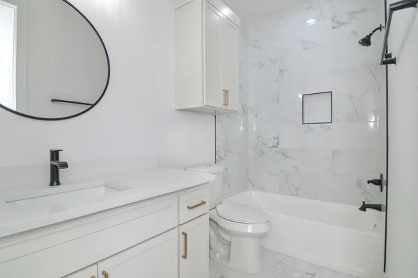 a bathroom with a sink a toilet and shower