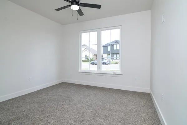 an empty room with a window and a ceiling fan