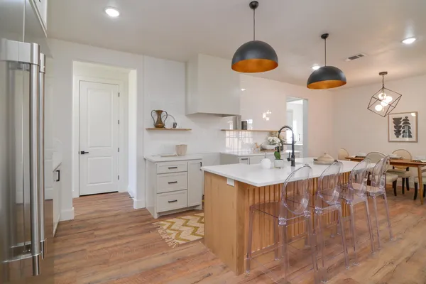 a kitchen with a stove chandelier and wooden floor