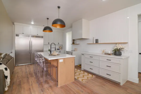 a kitchen with stainless steel appliances a stove a sink a refrigerator and cabinets