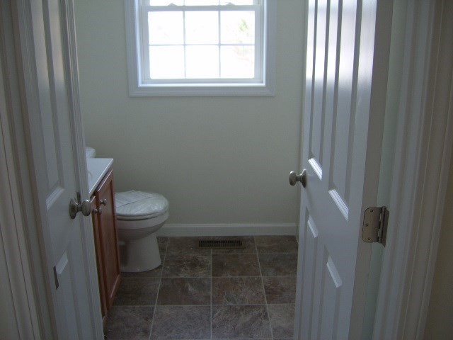 5 Bufton Farm Road, Unit 7 Clinton, MA 01510 - Photo 17 of 22 a white toilet sitting in a bathroom next to a window