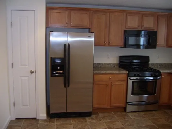 a kitchen with granite countertop a sink a window and cabinets