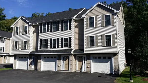 a view of residential houses with a yard and plants