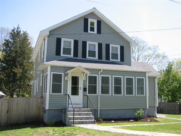 4 Spring Lane Stoneham, MA 02180 - Photo 1 of 13 a front view of a house with a yard