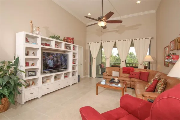 a living room with furniture a flat screen tv and a large window
