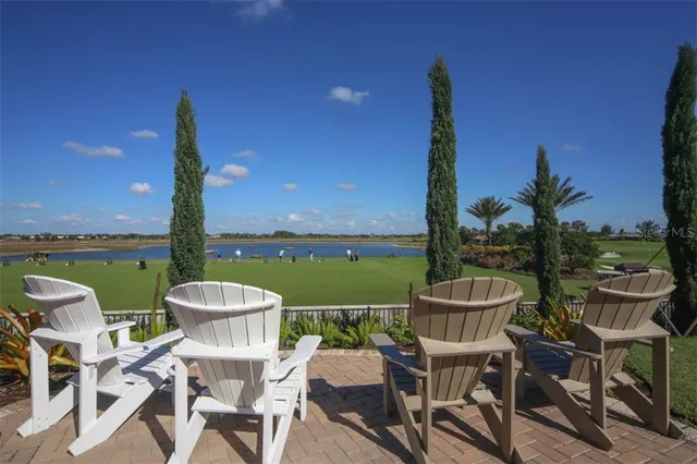 a view of a chairs and table in patio with a lake view