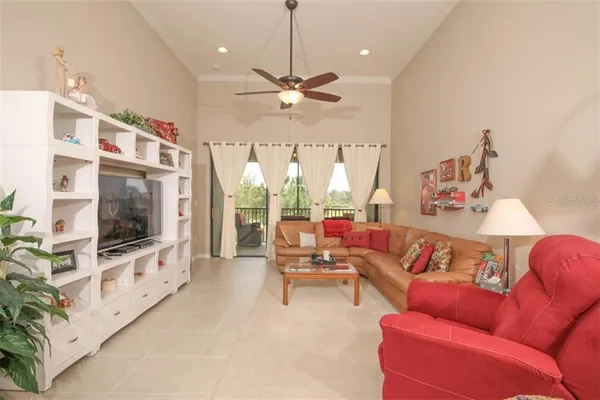 a living room with furniture a flat screen tv and a chandelier