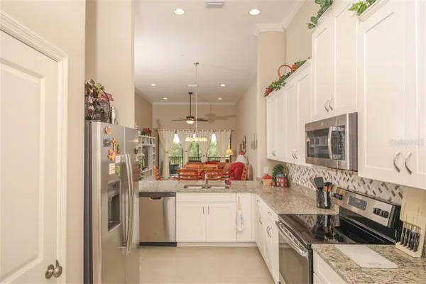 a kitchen with stainless steel appliances kitchen island granite countertop a sink stove and refrigerator