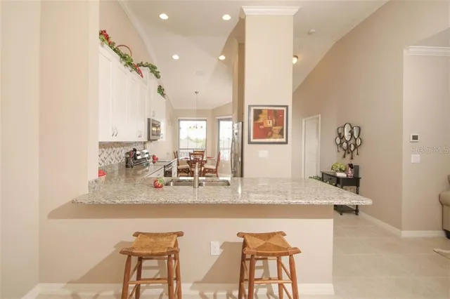 a dining room with kitchen island granite countertop furniture and a view of kitchen