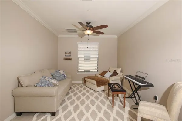 a living room with furniture and a ceiling fan