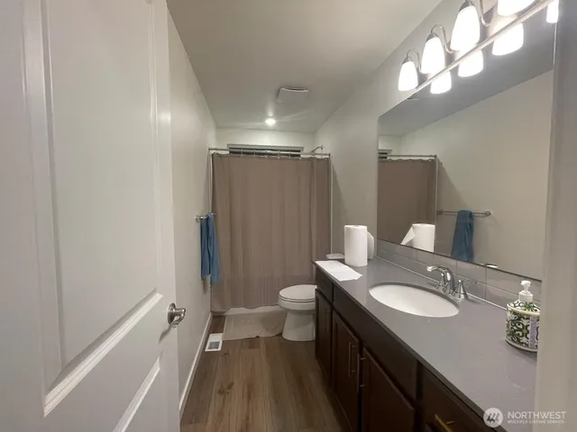 a spacious bathroom with a granite countertop sink toilet and shower