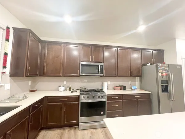 a kitchen with stainless steel appliances granite countertop a refrigerator stove and sink