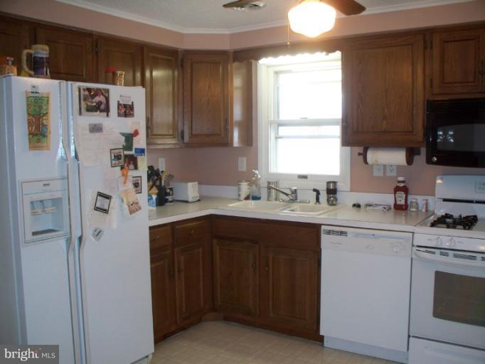3932 Highland Ridge Road Berkeley Springs, WV 25411 - Photo 2 of 30 a kitchen with a sink a refrigerator and window