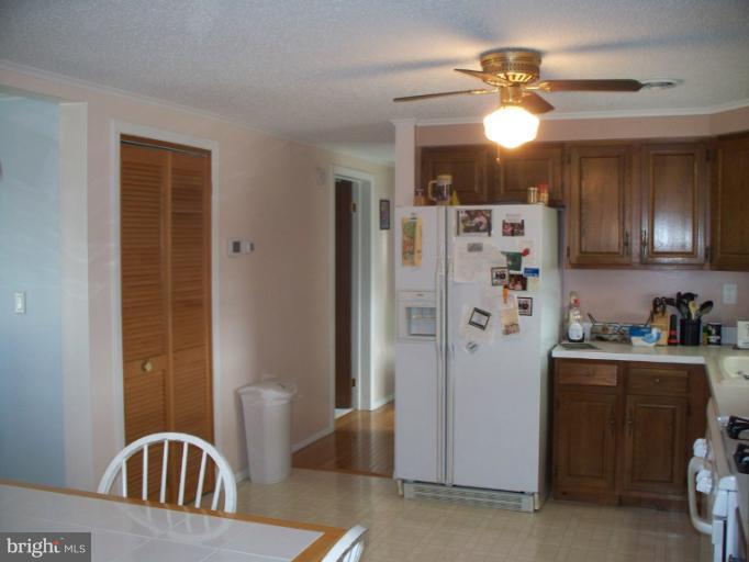 3932 Highland Ridge Road Berkeley Springs, WV 25411 - Photo 4 of 30 a kitchen with a refrigerator a sink and cabinets
