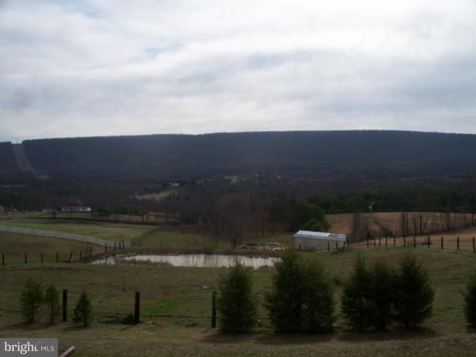 3932 Highland Ridge Road Berkeley Springs, WV 25411 - Photo 8 of 30 a view of a lake with a yard