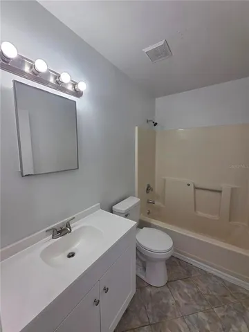 a bathroom with a sink a toilet a mirror and shower