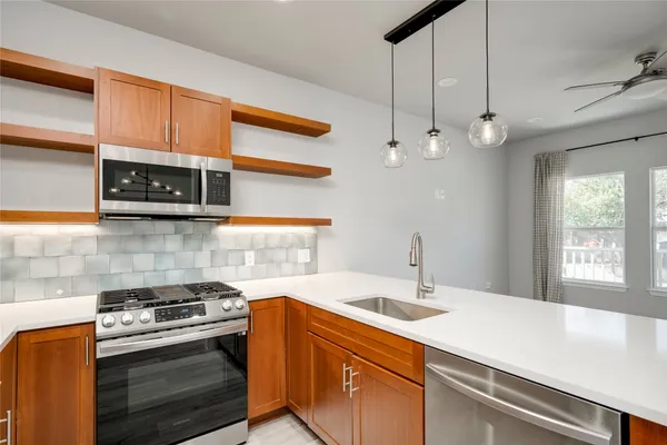 a kitchen with stainless steel appliances a sink a stove and cabinets