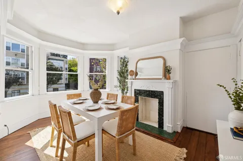 a dining room with furniture window and wooden floor