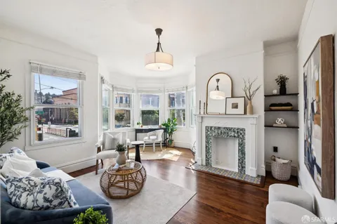 a living room with furniture fireplace and a large window