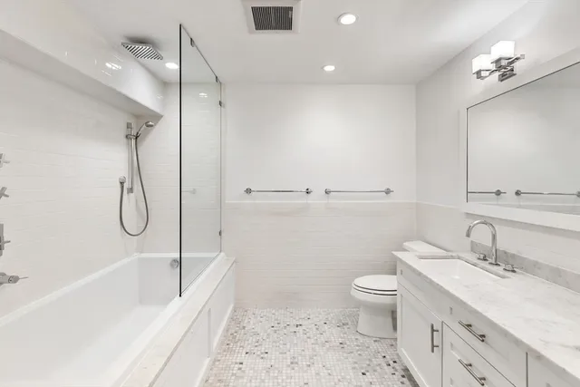 a bathroom with a sink a toilet and shower