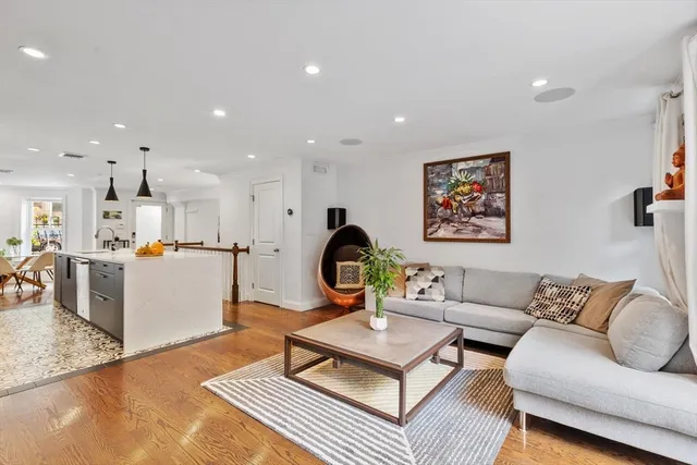 a living room with furniture a rug and kitchen view