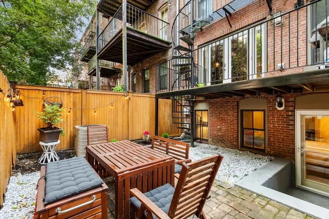 a view of a patio with table and chairs with wooden floor and fence