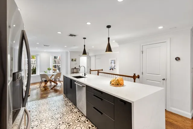 a kitchen with a sink a center island and chairs