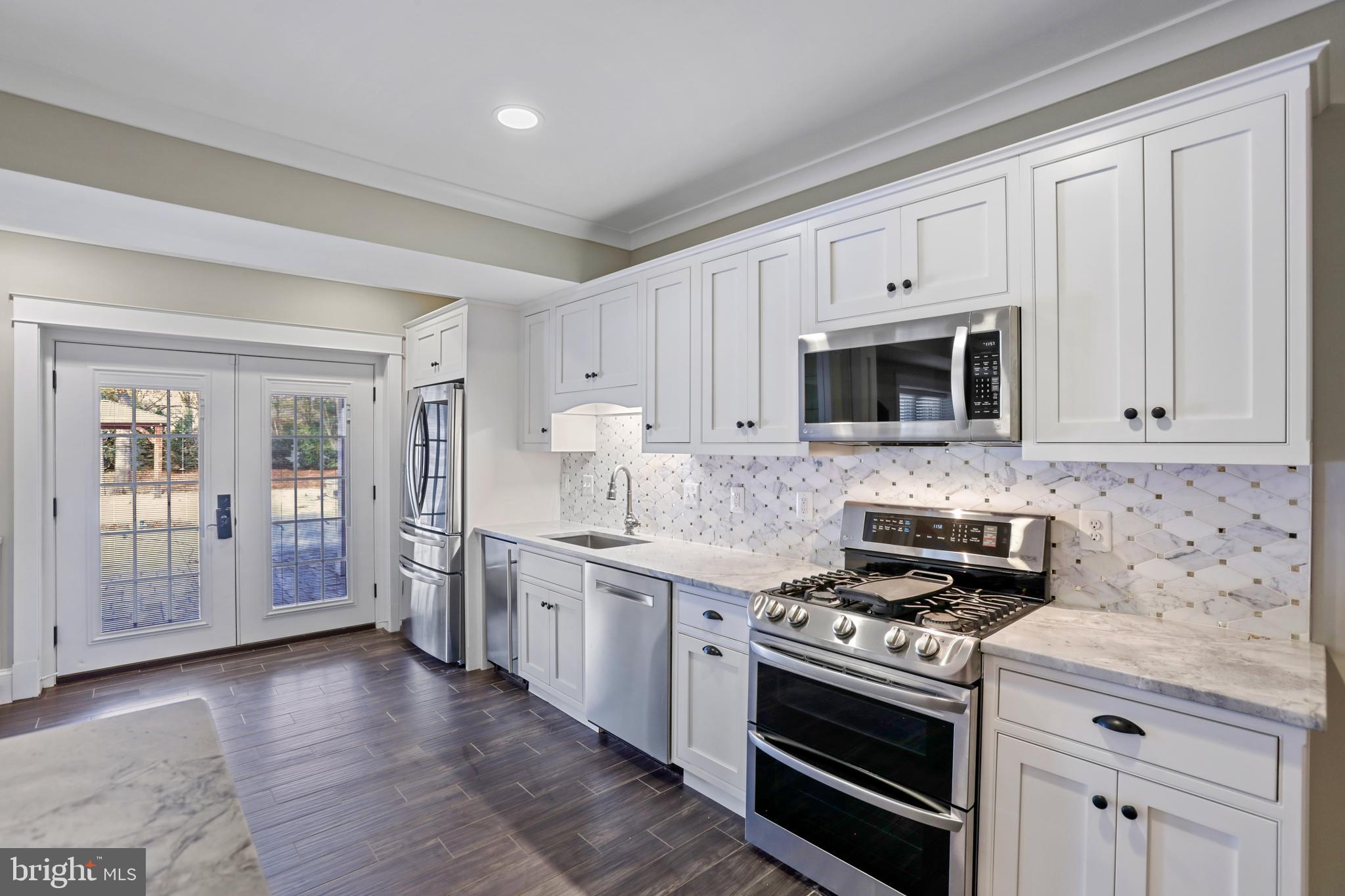 21490 Cedar Drive Sterling, VA 20164 - Photo 47 of 73 a kitchen with stainless steel appliances white cabinets and a stove top oven