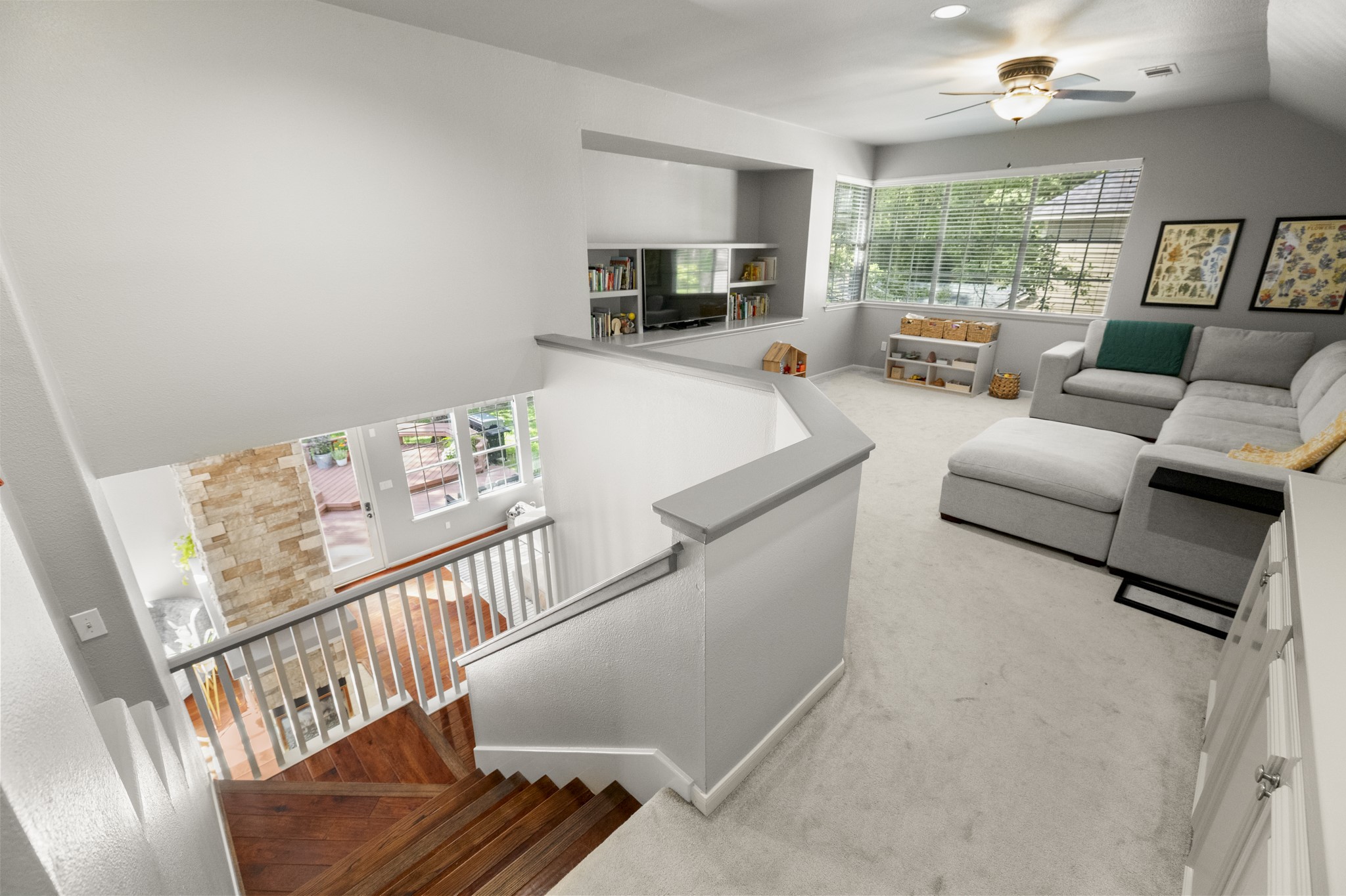 102 Treescape Circle Spring, TX 77381 - Photo 24 of 40 The view from the staircase highlights a beautiful view downstairs, adding warmth and elegance to the home.