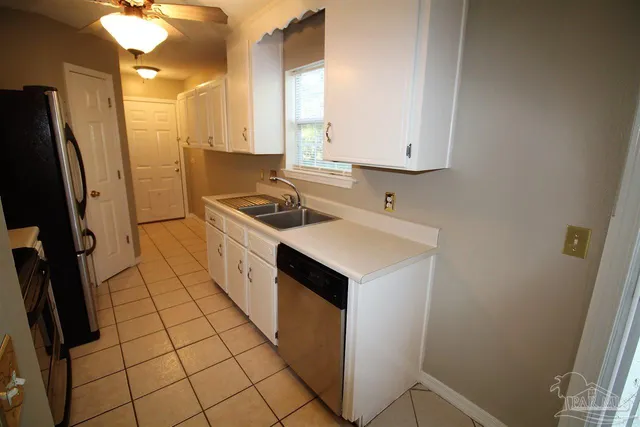 a kitchen with a sink a refrigerator and cabinets