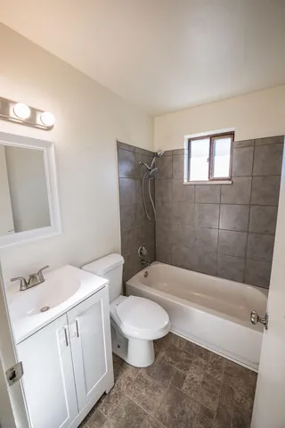 a white toilet sitting next to a bathroom sink and a mirror