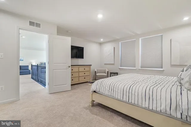 a spacious bedroom with a bed and a flat screen tv