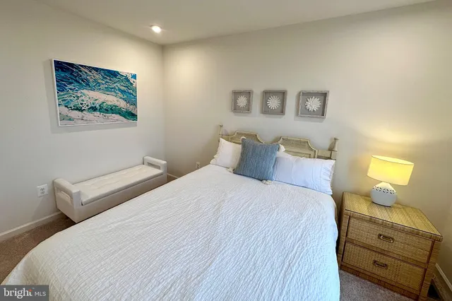 a bedroom with a bed and a lamp on dresser