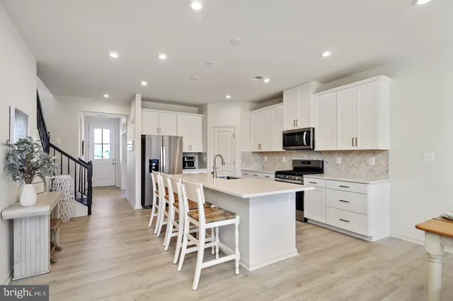 a kitchen with white cabinets and stainless steel appliances