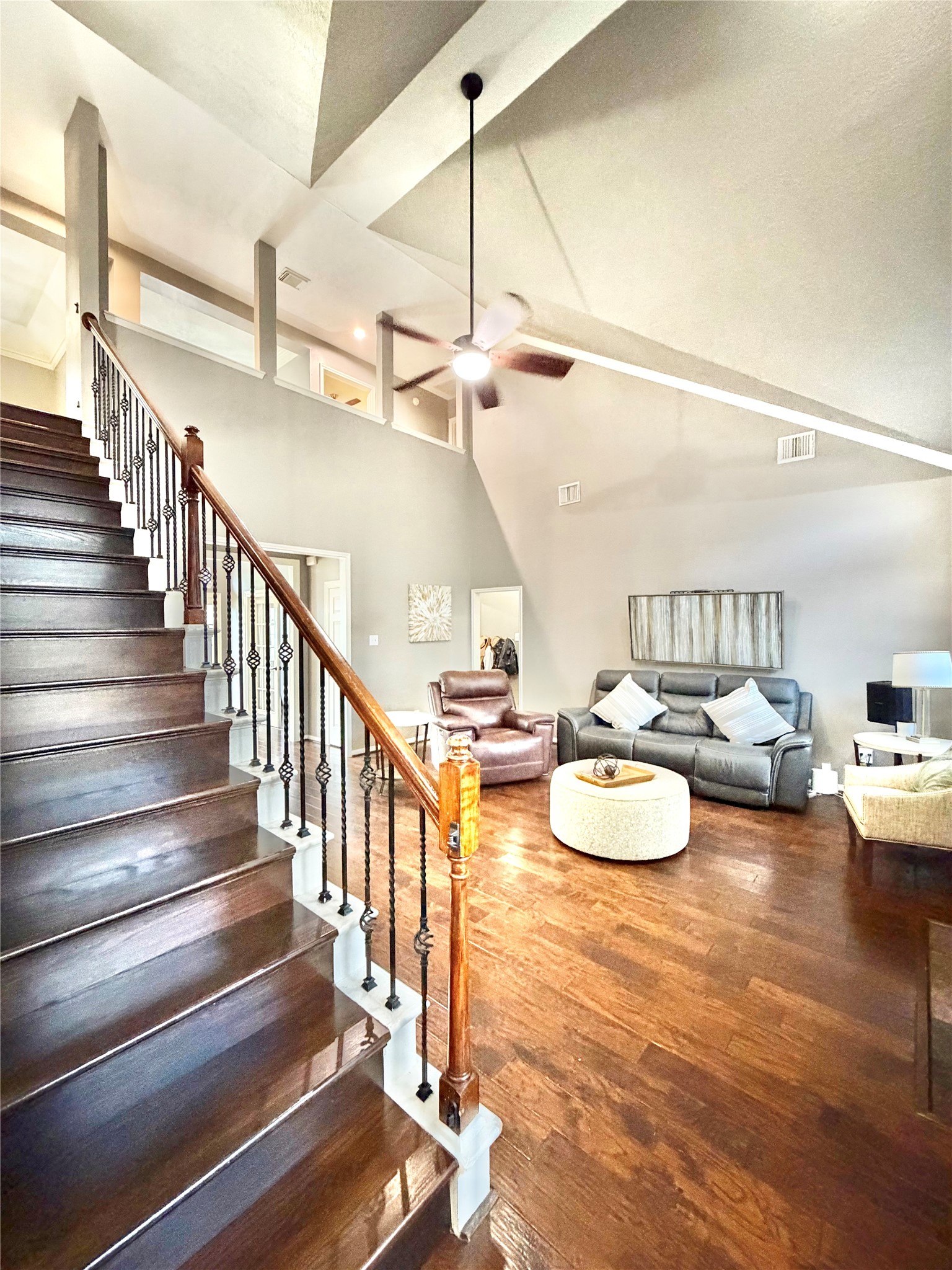 20110 Forest Drive Spring, TX 77388 - Photo 10 of 43 Expansive living area with soaring ceilings, elegant staircase, and warm hardwood floors, offering a perfect blend of style and comfort.