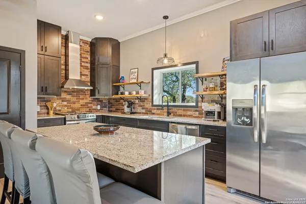 a kitchen with stainless steel appliances granite countertop a sink stove and refrigerator
