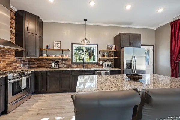 a kitchen with stainless steel appliances granite countertop a sink stove and cabinets
